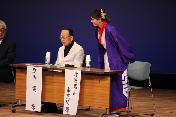 左から原田 護さんが座りその隣で紫の衣装を着た、丹波篠山 楽空間さんが立って話をしている写真