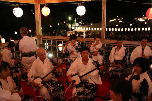 やぐら内で、楽器を演奏する男女の写真