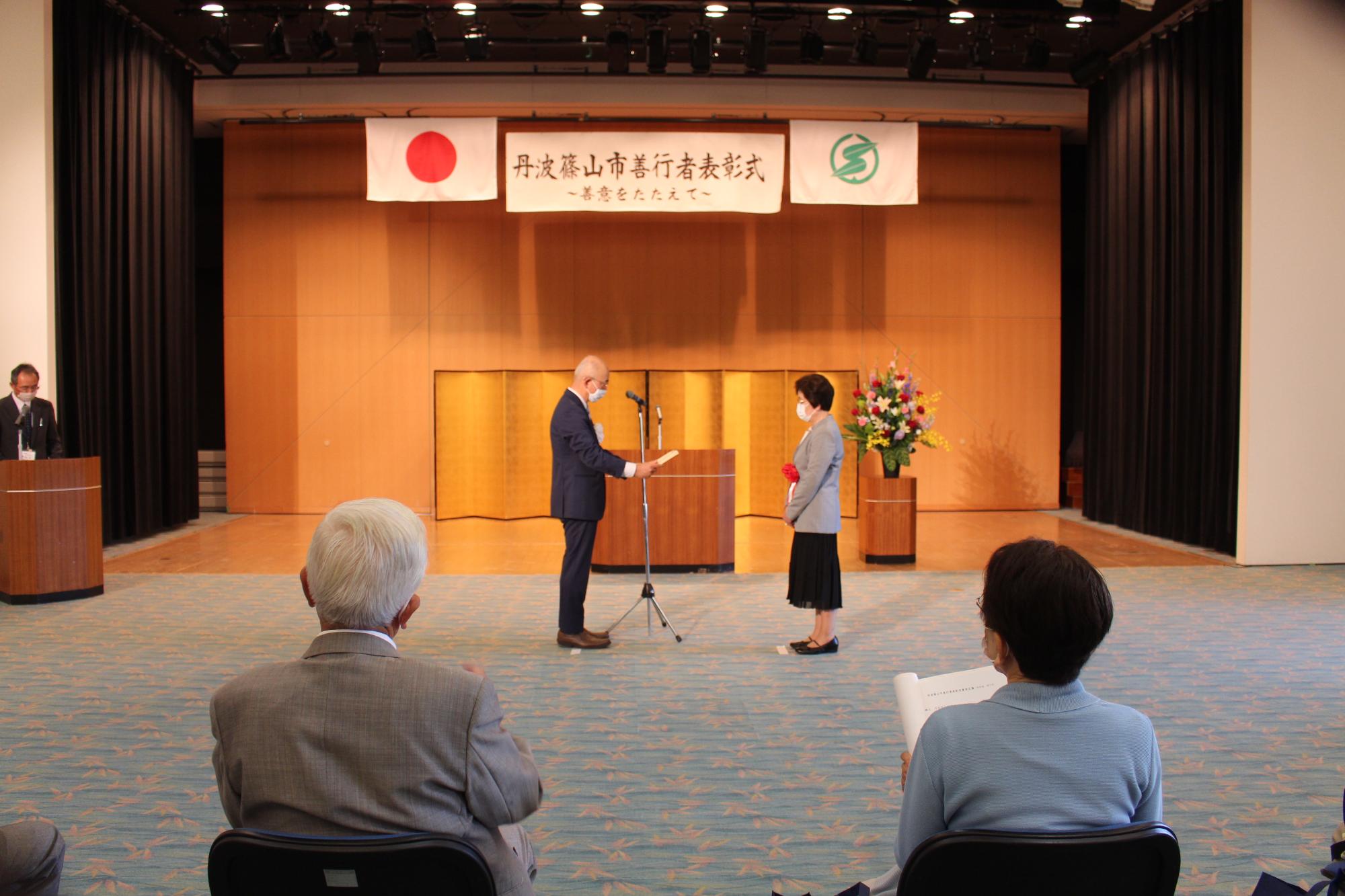 受賞者を前に、市長が表彰状を読み上げている。