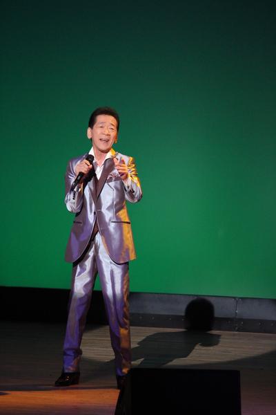 シルバーの派手なスーツを着た丹波ひろしさんが右手にマイクをもち熱唱している写真