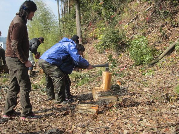 子供と男性が一緒に斧をもって木を割っている写真