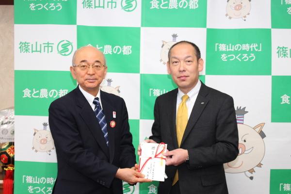 市長と代表取締役社長の降矢 寿民さんが寄附を2人で持って並んでいる写真