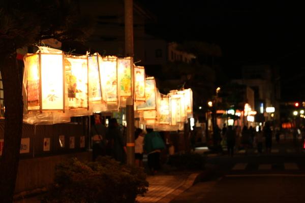 様々なイラストが描かれた灯篭がつるされている写真