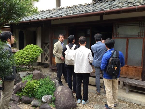 建物の前に集まり、中を見ている関係者の写真