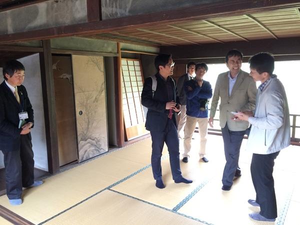 畳の部屋で、笑顔で話をしている関係者の写真