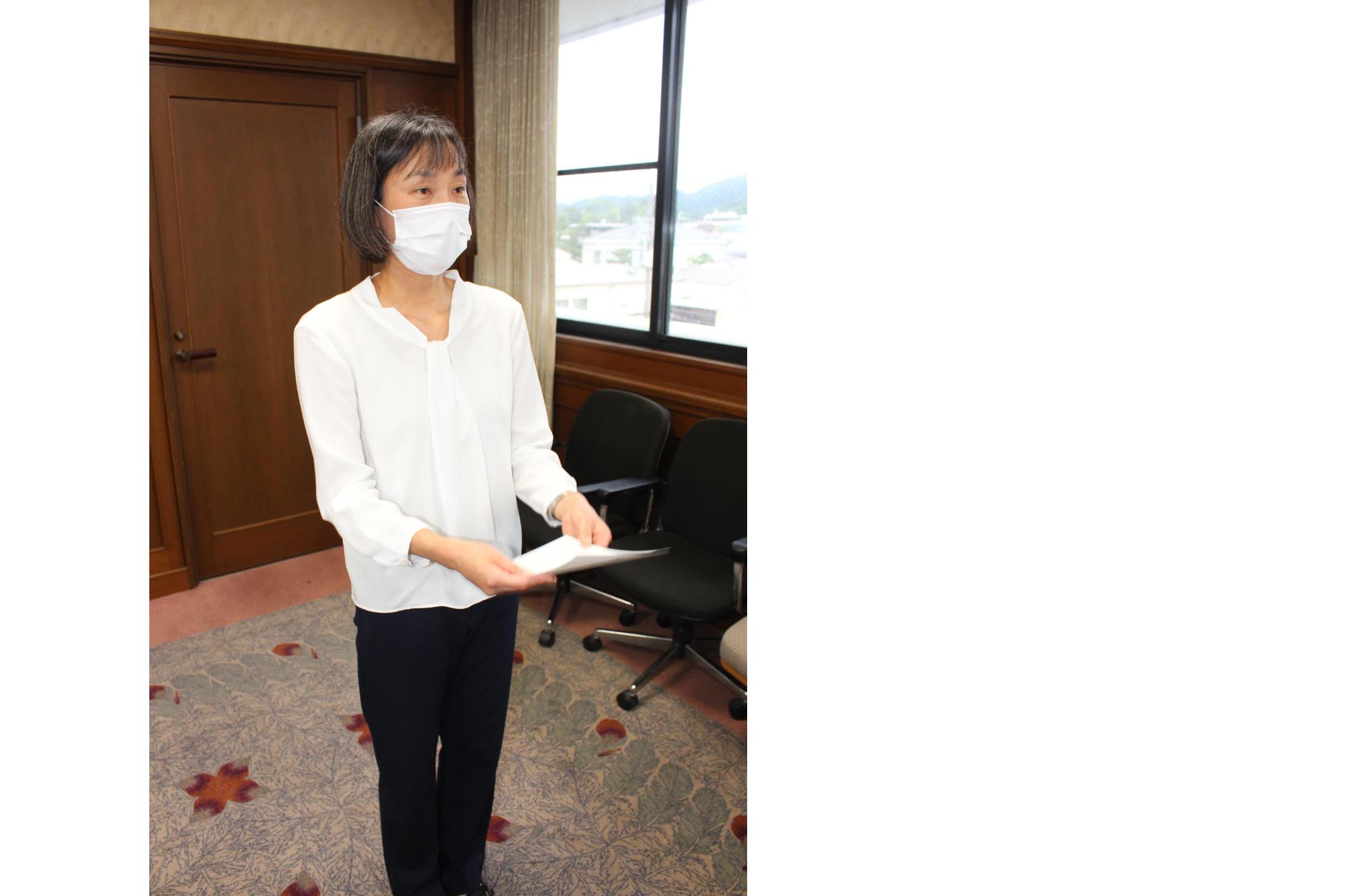 女性が辞令を受け取って両手で持っている