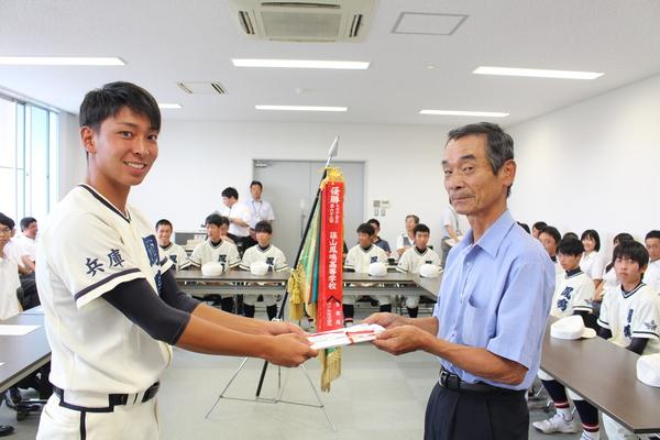 OB会の小野田さんから大木キャプテンに目録を渡している写真