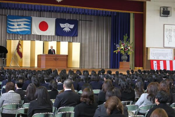 ステージ上の金屏風の前で市長が卒業生に向けて祝辞を述べている写真