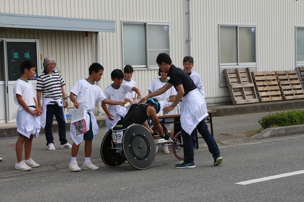 車いすマラソンで選手が給水をしている
