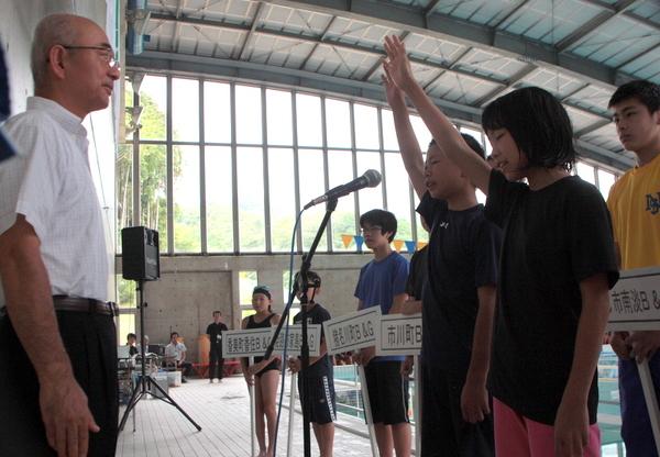 市長の前で男の子と女の子が代表で選手宣誓をしている写真