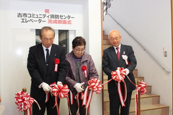 古市コミュニティ消防センターエレベーター完成披露式市長ら3名でのテープカットの写真