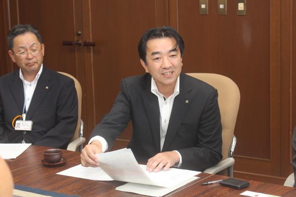 谷掛支店長と北尾さんが椅子に座り、右側の谷掛支店長が資料を手に取りながら話をしている写真