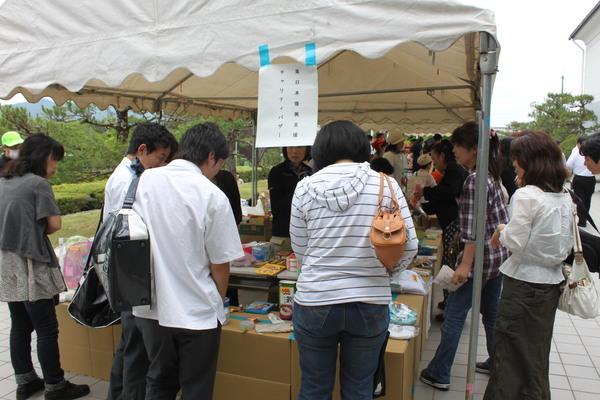 東日本大震災のチャリティーバザーで飾られている商品を見に来ている写真