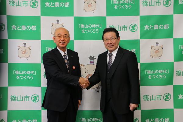 市長と内藤 正啓（ないとう まさひろ）さんが握手の記念写真