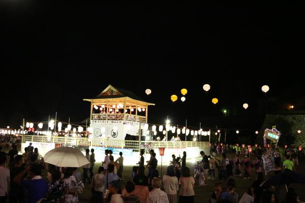 やぐらを囲み集まる沢山の人々の写真