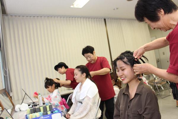 女性3名の髪の毛をセットしている美容師の方3名の写真