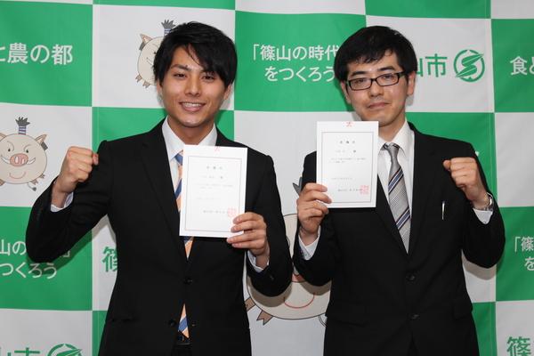 委嘱状をもってガッツポーズしている小牧 満也さんと石坂 将一さんの写真