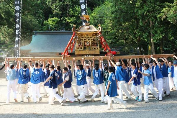 神社で法被姿の男性らが神輿を担いでいる写真
