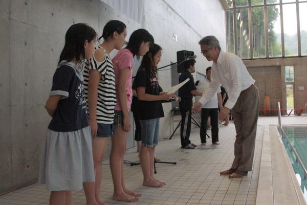 私服に着替えた女子生徒4名が表彰されている写真