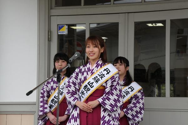 袴を着て、丹波篠山観光大使のタスキをする角穴 理香子さんが、マイクの前で話している写真