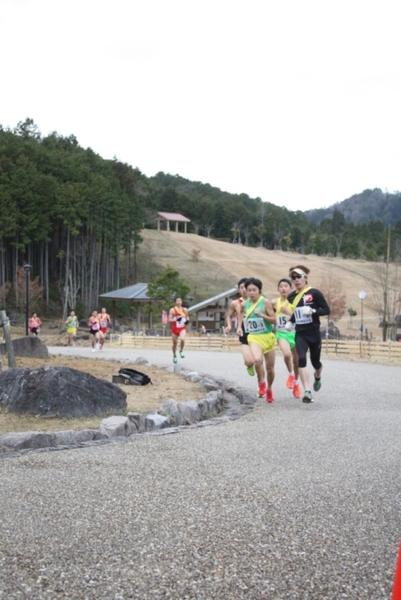 黄色のタスキをかけた10名ほどのランナーが道路を走っている写真