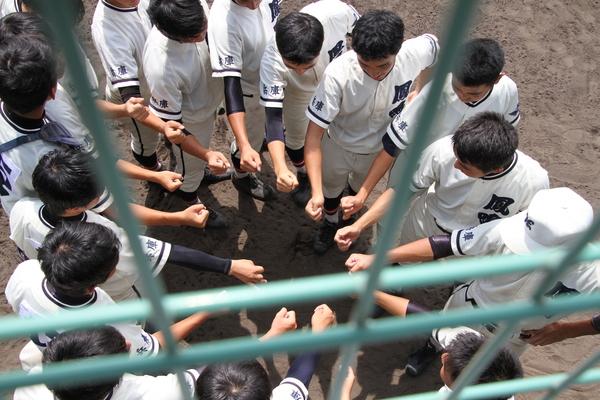 選手たちが円陣を組んで右手で拳を作り気合をいれている写真
