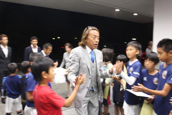 中央にはサッカーの北澤選手が立っていて、両脇の子供たちと手でタッチをしている写真