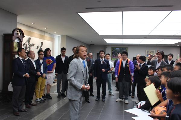 中央にはスーツ姿の北澤選手が立って話をしていて、大人の男性達や少年たちが北澤選手を囲んでいる写真