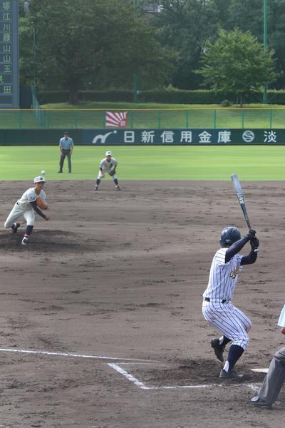篠山鳳鳴高校軟式野球部のピッチャーが、ボールを投げ、相手チームのバッターが構えている写真