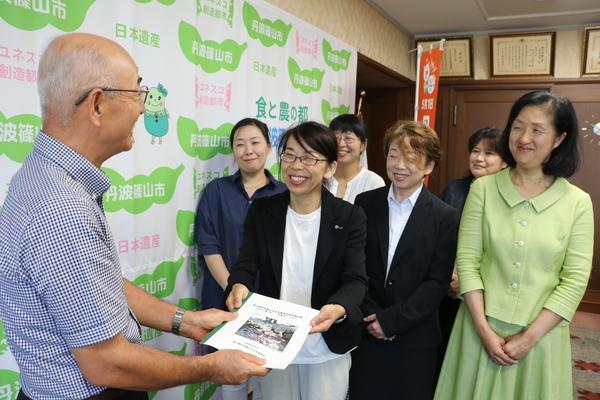 市長へ丹波篠山市女性委員会委員の方6名が提言報告書を渡している写真