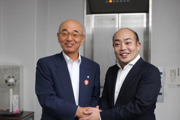 市長とギャロップ林さんが両手で握手をしており、満面の笑みで写っている写真