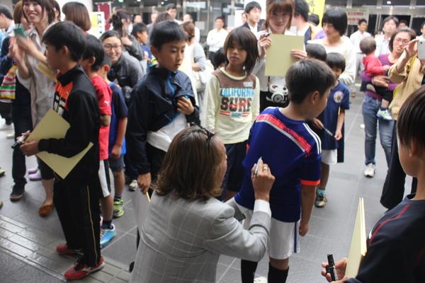 少年が着ているサッカーのユニフォームの背中側に北澤選手がペンでサインをしている写真