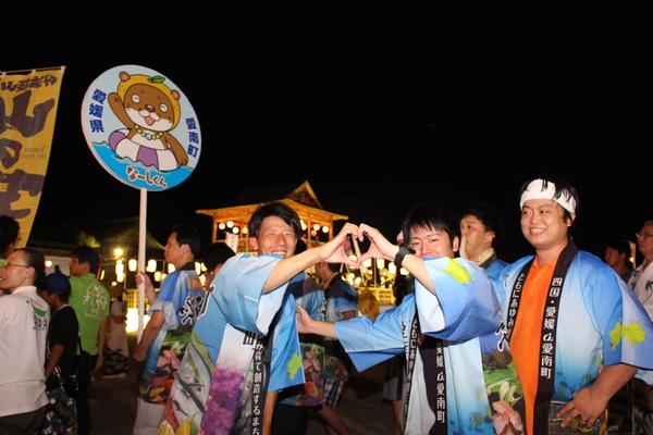 法被を着て、手でハートの形を作る男性2名とその隣でその様子をみて笑っている男性の写真