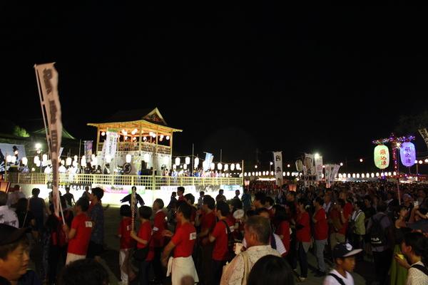 色々なプラカードや旗を持ち、やぐらの周りに集まる沢山の人々の写真