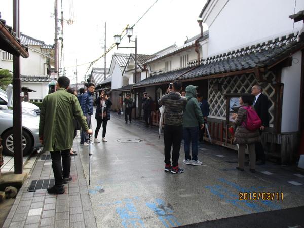 ブータンの若手行政官13人が写真を撮りながら町を散策している写真