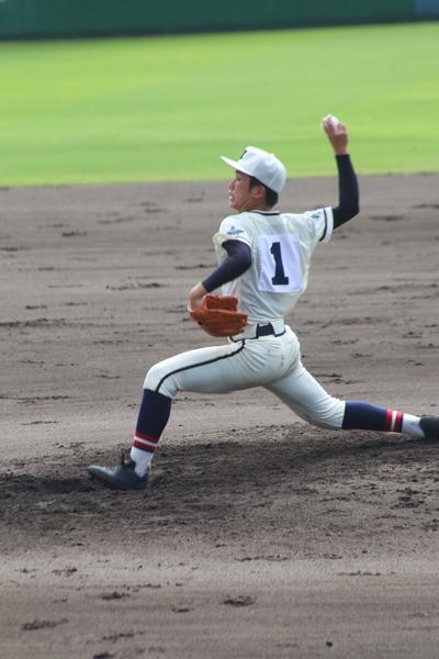 1番背番号の、篠山鳳鳴高校軟式野球部の選手が、低姿勢になって勢いよくボールを投げている写真