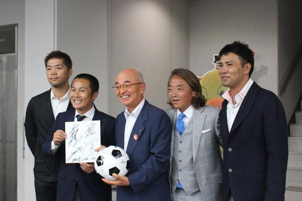 サッカーボールを持った市長とサッカー選手4人が並んでいる集合写真