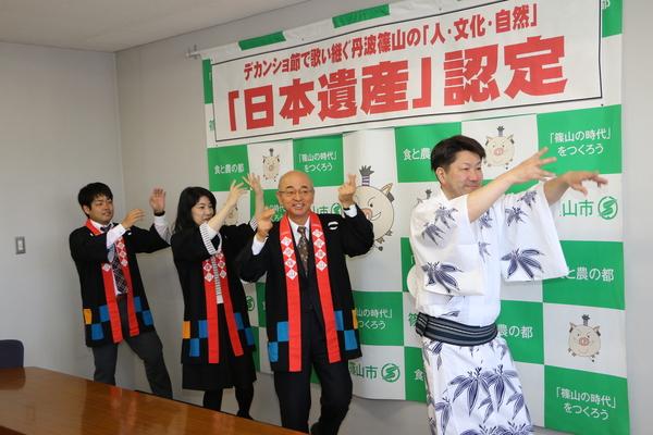 白地に笹の葉の絵が描かれている浴衣を着た男性を先頭に、法被を着た市長とその後ろに女性と男性の職員がデカンショを踊っている様子の写真