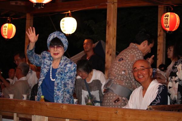 笑顔で手を振る桂 由美さんと、その横に座っている市長の写真