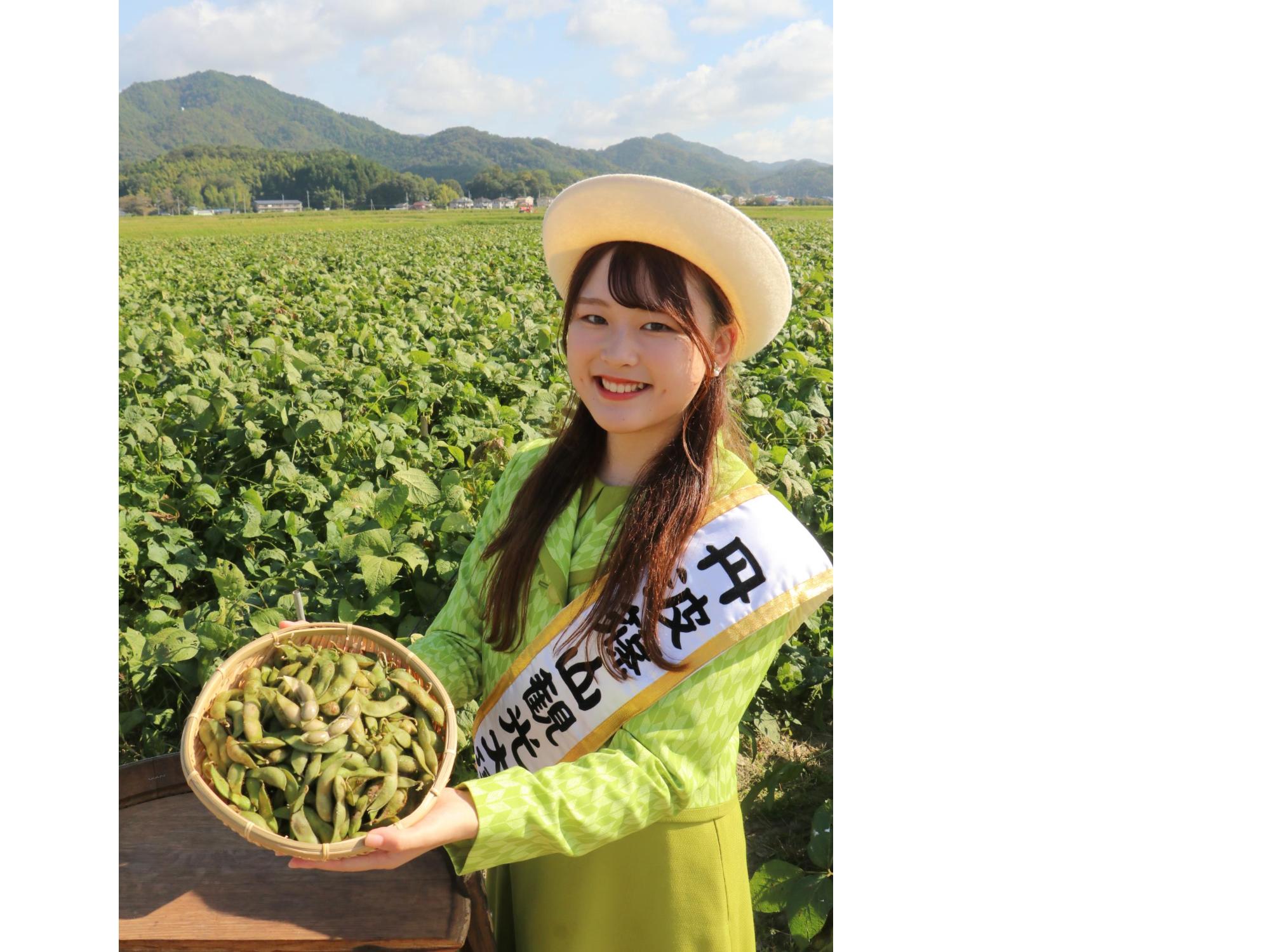 観光大使が竹籠に入れた黒枝豆を持っている