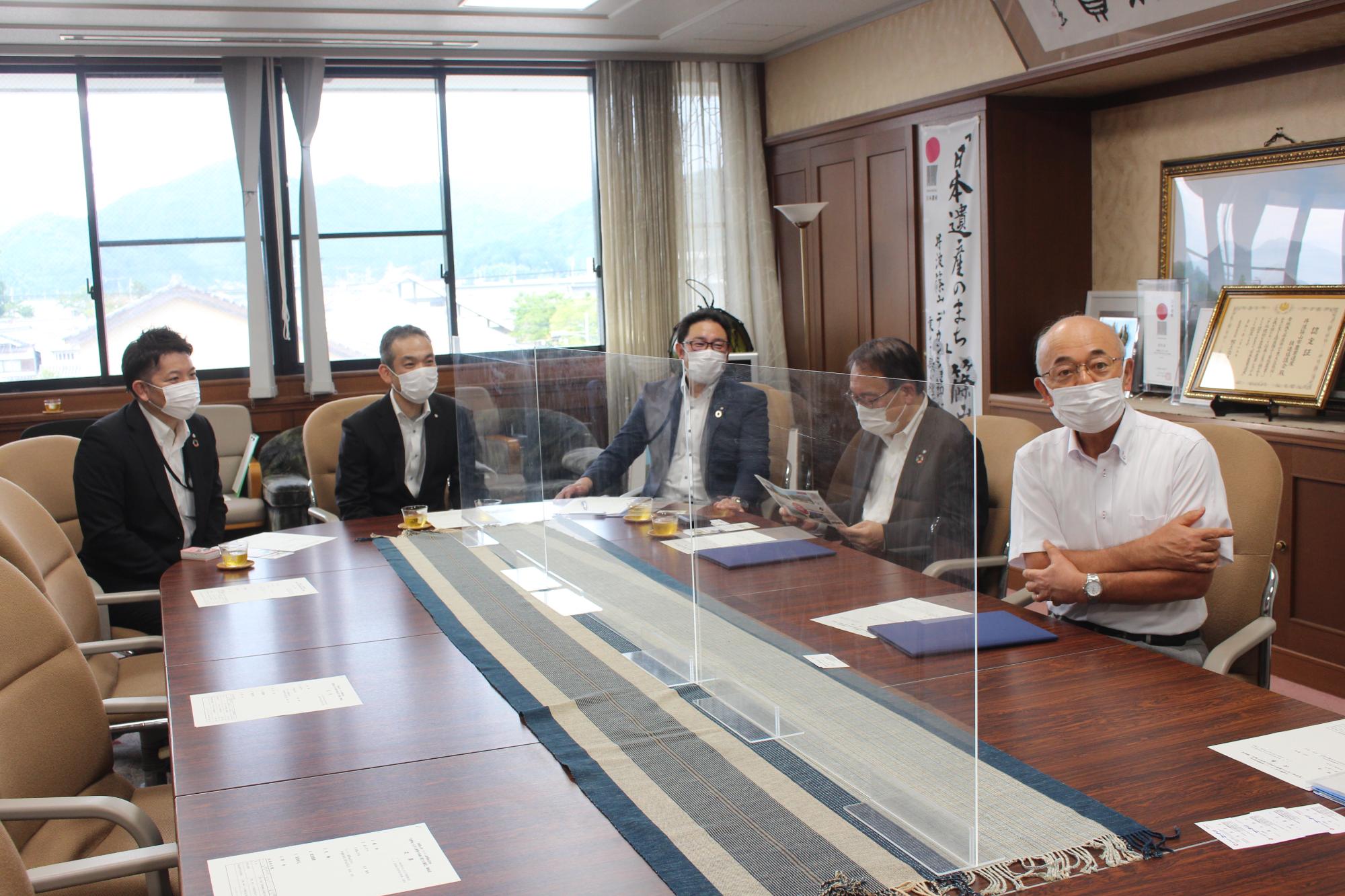 円卓に男性5人が座っている。