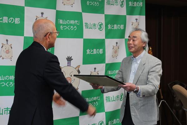 市長から久下 末男さんへ額縁に入った感謝状が贈られている写真