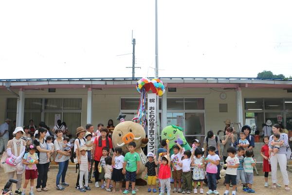 「おとわの森子育てママフィールド」のオープニングイベントでくす玉が割られており、ゆるキャラと親子らが記念撮影している写真
