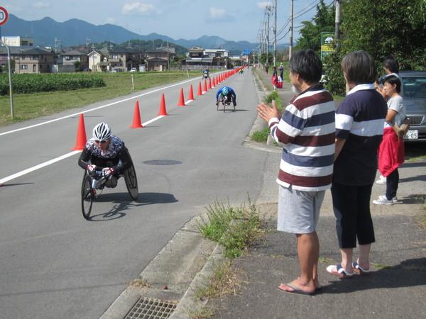 車いすのランナー達を沿道の人達が手を叩いて応援している写真