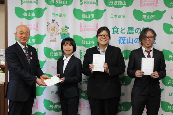 市長から賞状のようなものを渡されている池上さん、梅谷さん、板垣さんの写真