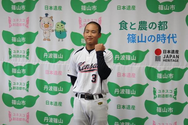野球のユニホームを着て左手を曲げてガッツポーズをしている萱野くんの写真