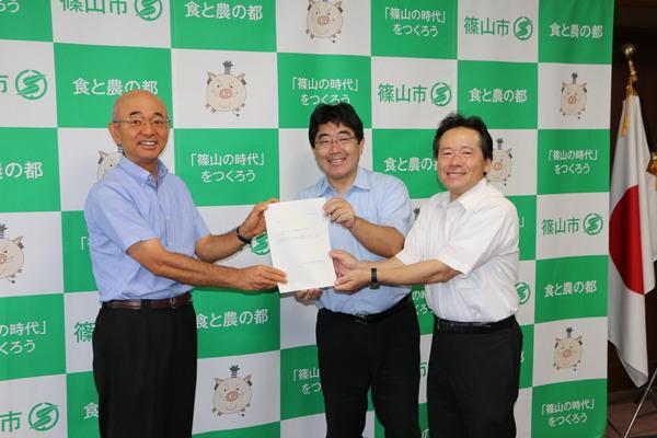 嘉田 眞典会長と大内 和彦委員が市長に報告書を手渡している写真