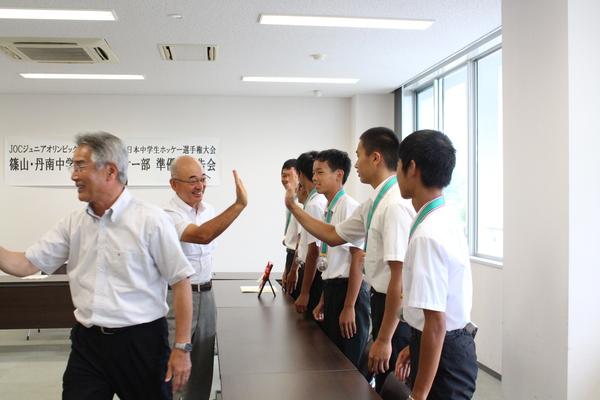 篠山・丹南中学校男子ホッケー部の選手と市長がハイタッチしている写真