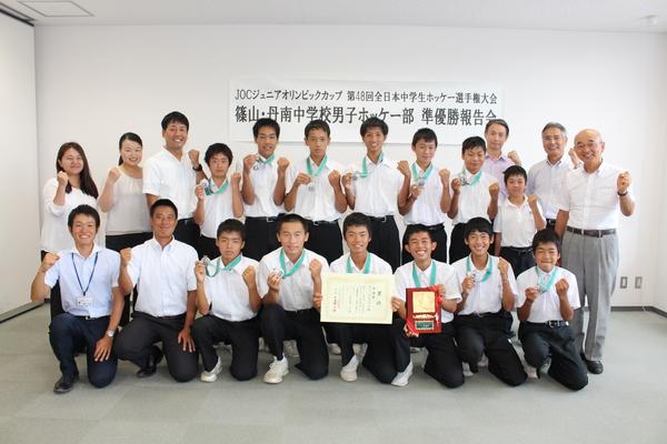 篠山・丹南中学校男子ホッケー部の選手がメダルと賞状と優勝盾を持ち、市長と記念写真