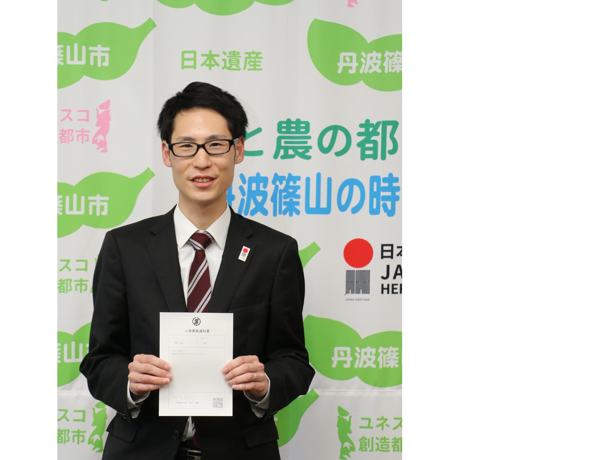 人事異動通知書を手に持つ男性職員